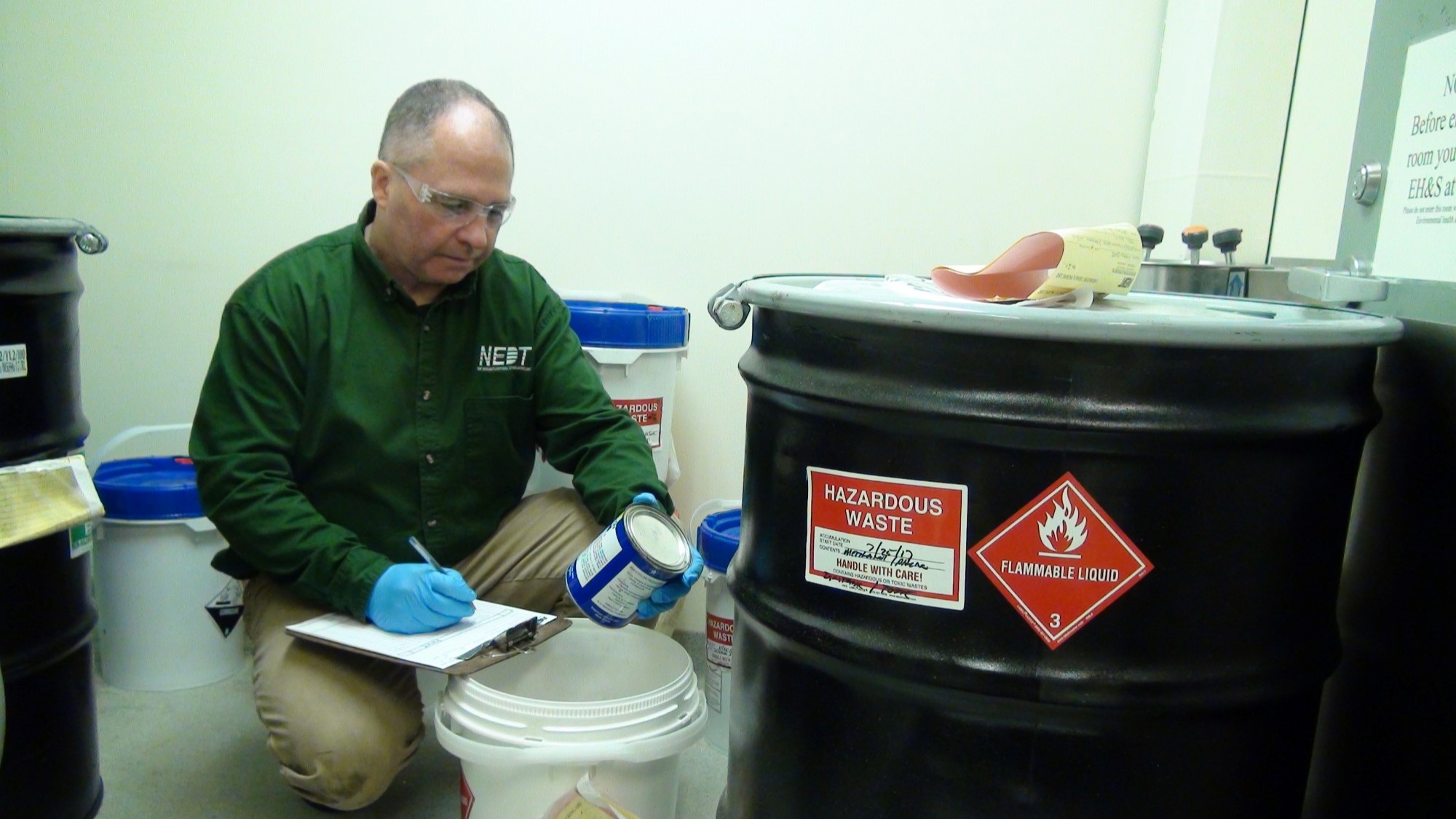 NEDT technician filling out hazardous waste forms for transportation and disposal.
